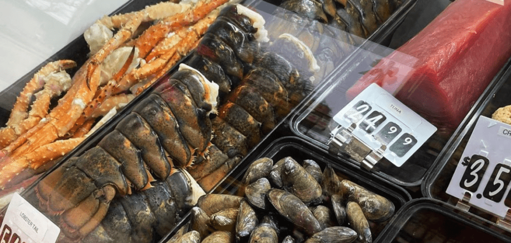 fresh lobster, crab and oysters behind glass